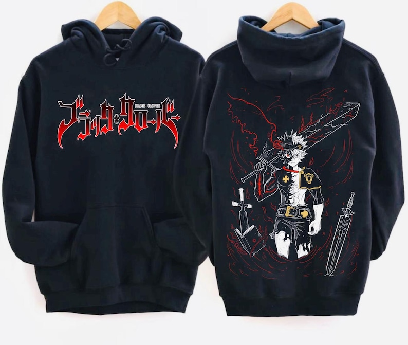 Może przedstawiać: Czarna bluza z kapturem z białym nadrukiem graficznym postaci z anime Black Clover. Na przodzie bluzy znajduje się napis "Black Clover".