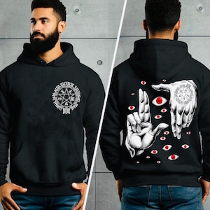 Peut inclure: Sweat-shirt à capuche noir avec un motif blanc d'un pentagramme et des caractères japonais sur le devant et un motif blanc de mains avec des yeux au dos.