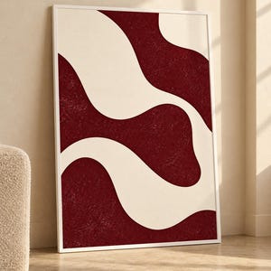 May include: A rectangular wall art piece in a thin white frame featuring a high-contrast design of deep burgundy, textured abstract shapes flowing against a smooth, solid off-white background, creating a bold, organic, and layered visual composition.