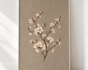 May include: A vertical rectangular wall art print featuring a detailed illustration of a flowering almond branch with white and pale pink blossoms. The branch is set against a solid, textured, muted beige background within a thin white frame.