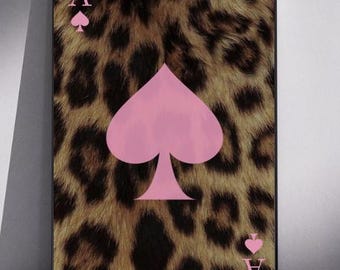 May include: A rectangular wall art print featuring an ace of spades playing card design. The background displays a brown and black leopard print pattern. A large, solid light pink spade symbol is centered, with smaller pink A and spade icons.