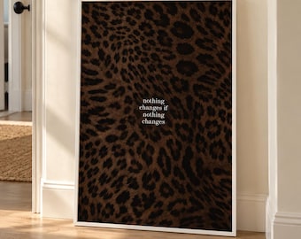 May include: A rectangular wall art print in a white frame featuring a brown and black leopard print pattern. Centered on the print is the white text that reads, nothing changes if nothing changes, in a simple serif font.