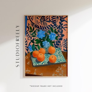 Puede incluir: Una impresión artística enmarcada que presenta una composición de naturaleza muerta. La obra de arte representa un jarrón con flores azules, naranjas y un mantel con estampado. El fondo tiene un diseño floral rosa y azul. El texto "STUDIOFREELY" está en el lado izquierdo del marco.