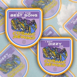 May include: Two purple and orange stickers with a cartoon image of a roller coaster. The text on the stickers reads "I got the best song on Cosmic Rewind" and "I got dizzy on Cosmic Rewind".