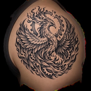 May include: A black and gray tattoo design featuring a phoenix with expansive wings, surrounded by swirling flames and mechanical gear elements. The bird is depicted in profile with detailed feather shading, integrated into a circular composition.