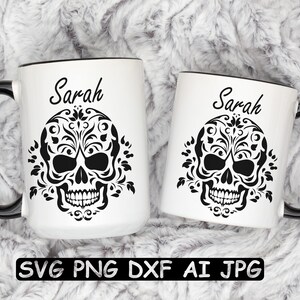 Może przedstawiać: Dwa białe ceramiczne kubki z czarnymi uchwytami i czarnymi obw&oacute;dkami. Każdy kubek ma czarny i biały wz&oacute;r czaszki z kwiatowymi detalami i imieniem "Sarah" nadrukowanym nad czaszką.