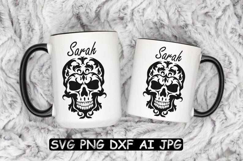 K&ouml;nnte beinhalten: Zwei wei&szlig;e Keramikbecher mit schwarzen Henkeln und schwarzen R&auml;ndern. Die Becher zeigen ein schwarz-wei&szlig;es Bild eines Sch&auml;dels mit floralen Mustern. Der Text "Sarah" ist auf jedem Becher aufgedruckt.