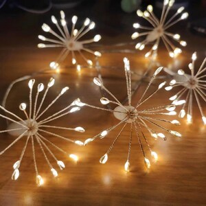K&ouml;nnte beinhalten: Eine Lichterkette mit Sternen-Design. Die Lichter sind warmwei&szlig; und haben einen Kupferdraht. Die Lichter sind kreisf&ouml;rmig zusammengef&uuml;gt und eignen sich perfekt zum Dekorieren eines Hauses oder einer Party.