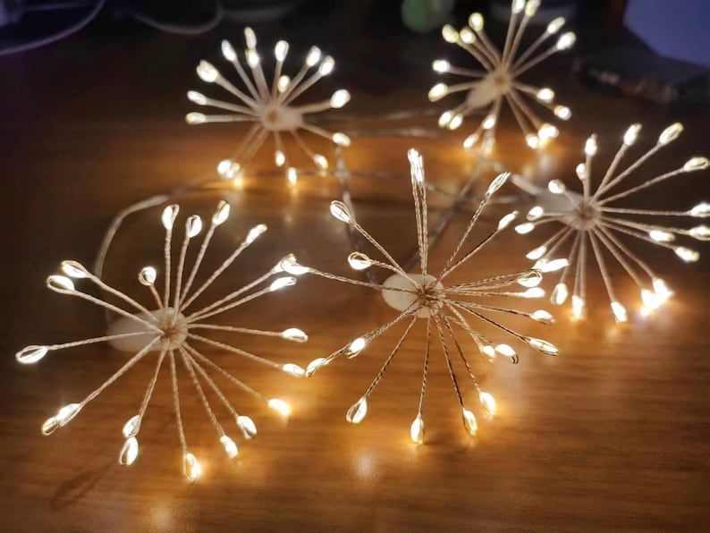 K&ouml;nnte beinhalten: Eine Lichterkette mit Sternen-Design. Die Lichter sind warmwei&szlig; und haben einen Kupferdraht. Die Lichter sind kreisf&ouml;rmig zusammengef&uuml;gt und eignen sich perfekt zum Dekorieren eines Hauses oder einer Party.