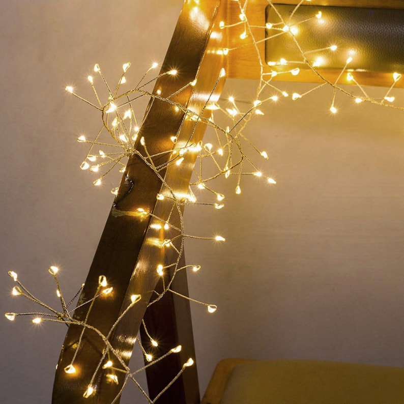 Pu&ograve; includere: Una ghirlanda di luci bianche calde con un design delicato a forma di rami. Le luci sono avvolte attorno a una superficie in legno, creando un'atmosfera calda e accogliente.