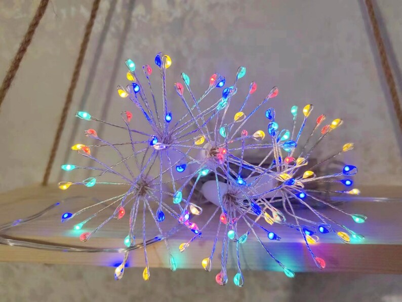 K&ouml;nnte beinhalten: Ein Satz mehrfarbiger Lichterketten in Form eines L&ouml;wenzahns mit silbernem Draht. Die Lichter sind miteinander verbunden und haben einen warmwei&szlig;en Schein.
