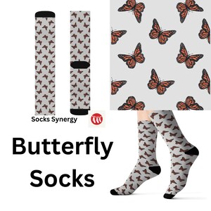 May include: Butterfly socks with a repeating pattern of orange and black monarch butterflies on a light gray background. The socks have black heels and toes. The words "Butterfly Socks" are displayed in large black letters.