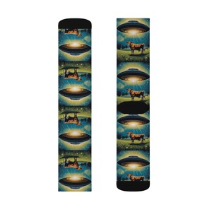 May include: Black socks featuring a repeating pattern of a cow being abducted by a UFO. The design includes a brown and white cow, a glowing UFO, and a starry night sky. The socks are made of a soft, comfortable material.