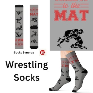 May include: A pair of gray wrestling socks with black wrestling silhouettes and the text "Let's Take It to the Mat" in red. The socks are shown on a model's feet.