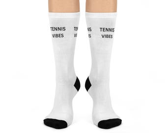 May include: White socks with black heels and toes. The text "TENNIS VIBES" is printed in black on the side of each sock. These socks are perfect for tennis enthusiasts or anyone who enjoys a sporty look.