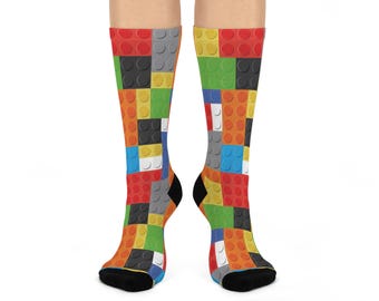 Könnte beinhalten: Ein Paar bunte Socken mit einem Lego-Stein-Muster. Die Socken sind schwarz, rot, gelb, blau, grün und grau.