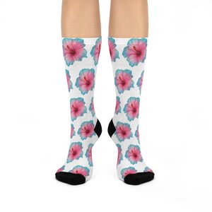 May include: A pair of white socks with a pink and blue hibiscus flower pattern. The socks are made of a soft, comfortable material and are ideal for everyday wear.