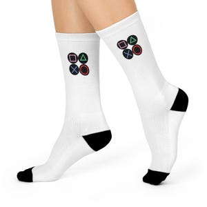 May include: White socks with black heels and a black and colored PlayStation controller button design on each sock.