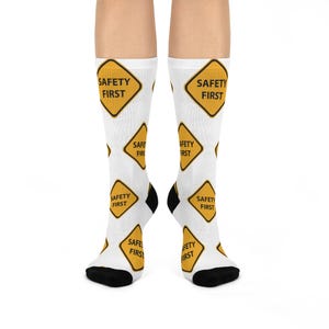 May include: White socks with a yellow and black safety first sign repeated on the socks.