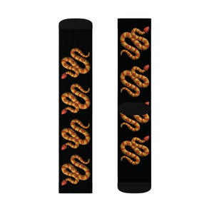 May include: A pair of black socks with a repeating pattern of orange and red snakes on a black background.