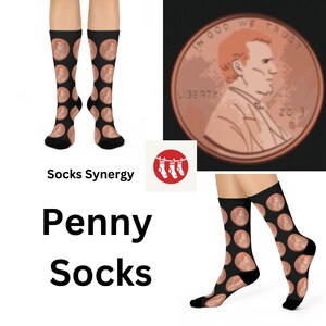 May include: A pair of black socks with a repeated image of a copper penny featuring the profile of Abraham Lincoln. The socks are displayed on a white background with the text "Socks Synergy" and "Penny Socks".