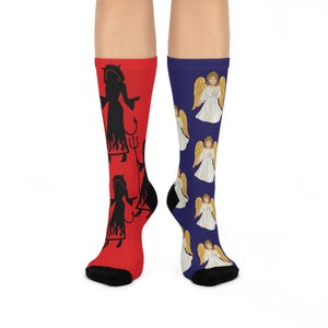 May include: A pair of knee-high socks. One sock is red with a black silhouette of a devil holding a trident. The other sock is blue with a pattern of angels in white robes and gold wings. Black heels and toes.