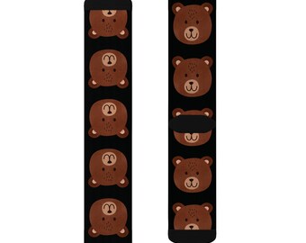 May include: A pair of black socks with a repeating pattern of brown bear faces. The socks are shown on a white background.