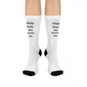 May include: White socks with black heels and toes. The text "I Really Really Miss Orlando, USA" is printed on the front of each sock. The socks are worn on a person's legs.