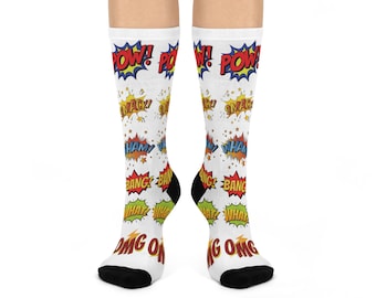 May include: White socks with comic book-style sound effects in red, yellow, blue, and green. The words "POW!", "SMACK!", "HAM!", "BANG!", "WHAT!", and "OMG!" are displayed on the socks. The heels and toes are black.
