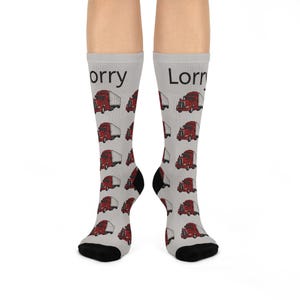 May include: Gray socks with a pattern of red semi-trucks and white trailers. The word "Sorry" is printed on one sock and "Lorry" on the other. The socks have black heels and toes.