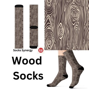Può includere: Un paio di calzini con un motivo a venature del legno. I calzini sono marroni con un design a venature del legno beige chiaro. I calzini hanno talloni e dita neri. Le parole "Wood Socks" sono stampate in nero.