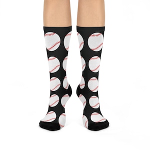 Könnte beinhalten: Schwarze Kniestrümpfe mit einem sich wiederholenden Muster aus weißen Basebällen mit roten Nähten. Die Socken bedecken die Füße und Unterschenkel.