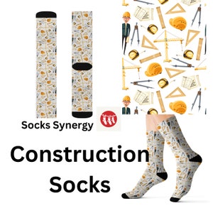 Peut inclure: Une paire de chaussettes blanches sur le thème de la construction. Les chaussettes présentent un motif d'outils, de plans et de casques de chantier. Les chaussettes sont présentées sur un fond blanc avec le texte "Socks Synergy" et "Construction Socks".