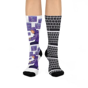 Pode incluir: Um par de meias brancas com calcanhares e dedos pretos. Uma meia apresenta uma figura roxa com capuz codificando em um computador com telas roxas. A outra meia tem um padrão de teclado em preto e branco.