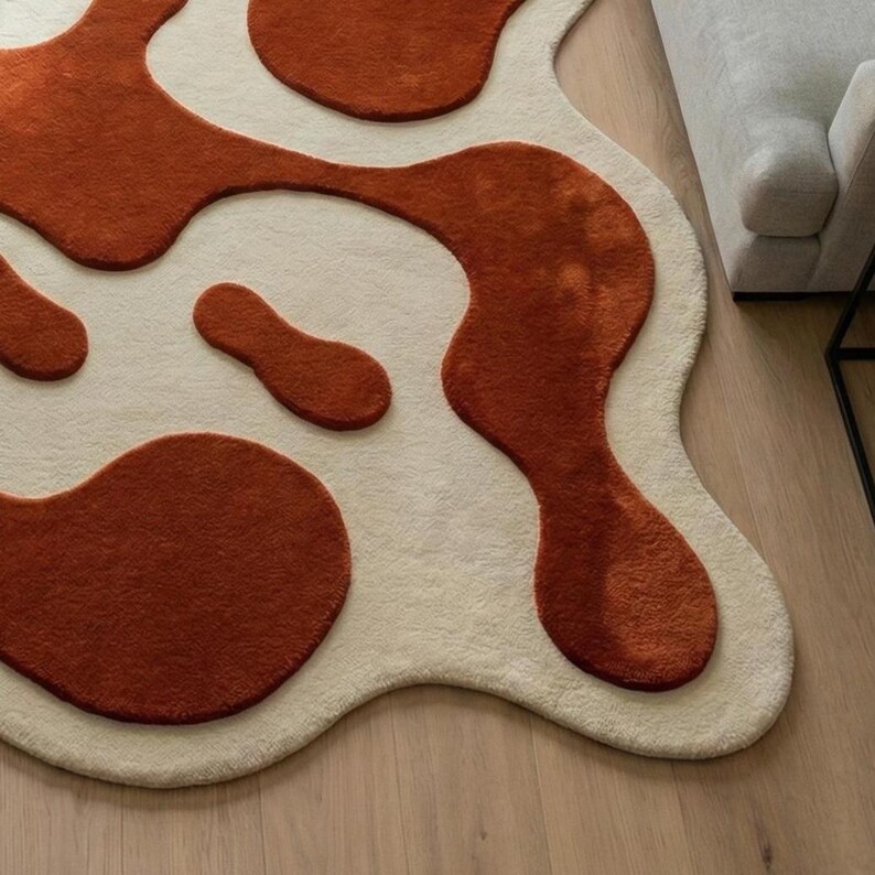 The natural wool fibers provide durability and softness, making this rug ideal for modern living spaces seeking warmth, texture, and handcrafted design elements. Styled in a minimalist living room with soft furnishings and natural light, this designer rug adds visual movement, cozy comfort, and artistic sophistication to modern interiors.