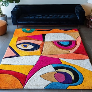 Abstract modern wool rug by Rugs By Mirzapur featuring vibrant cubist face-inspired designs in red, yellow, pink, ivory, and blue. Hand-tufted by skilled artisans, this colorful carpet adds artistic charm and luxury to contemporary living rooms, offering durability, softness, and a striking statement style inspired by modern art movements.