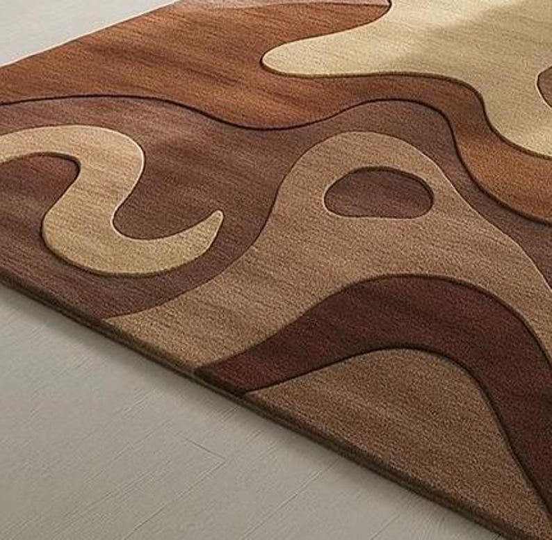 Modern abstract area rug with organic curves and wavy design in warm tones of brown, tan, and cream. Handcrafted with sculptural wool texture, perfect for U.S. contemporary homes.