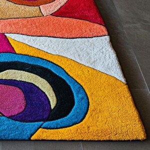 Contemporary abstract rug handmade by Rugs By Mirzapur, featuring multicolor cubist patterns and artistic facial motifs. Crafted with luxurious wool, it offers comfort, resilience, and a tactile feel. Perfect for modern, eclectic, or boho interiors, this rug brings energy, creativity, and expressive art-inspired design to any home décor.