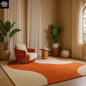 May include: A striking orange and cream-coloured rug with a flowing design is the focal point of the room. An orange armchair with cream cushions complements the rug. The room includes plants, a small wooden table, and neutral-toned curtains.