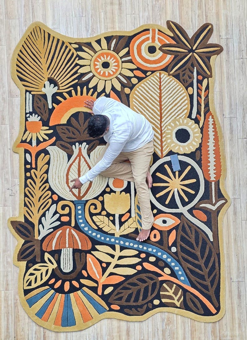 Wool wall rug artwork with folk floral design, blending earthy tones and organic shapes for a cozy modern aesthetic.