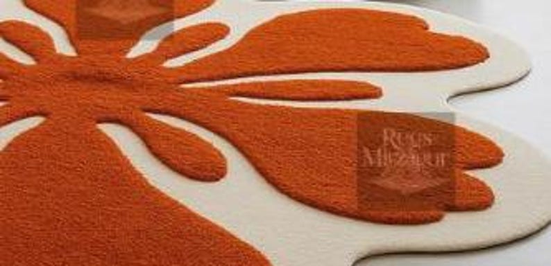 Large soft wavy rug centerpiece with playful organic shapes in vibrant tangerine and ivory tones.