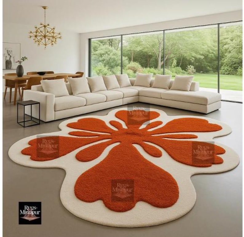 Modern groovy orange and cream flower-shaped rug in minimal living room with panoramic garden view.