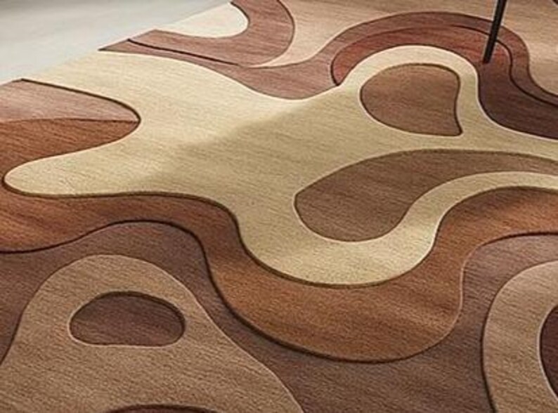 Sculptural high-low wool rug with abstract forms in camel, mocha, and ivory. A soft statement piece for American minimalist, boho, or modern interiors.