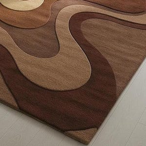 Artistic floor rug with 3D pile contours in brown gradients and cream tones. Hand-tufted wool, designed for cozy, curated U.S. living spaces.
