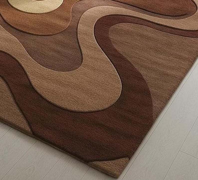 Artistic floor rug with 3D pile contours in brown gradients and cream tones. Hand-tufted wool, designed for cozy, curated U.S. living spaces.