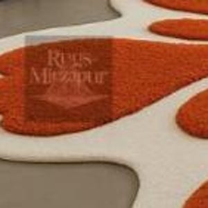 Statement shag rug in bright orange floral motif, ideal for maximalist or boho decor lovers.