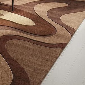 Neutral hand-tufted rug in beige and brown with bold, curvy design. High-low texture adds depth to U.S. homes with earthy or mid-century styling.