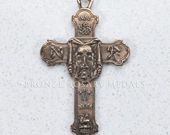 May include: A bronze rosary crucifix with a detailed image of Jesus' face, a crown of thorns, and other religious symbols. The crucifix is a religious item for prayer and meditation.