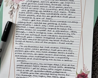 May include: A handwritten letter to Chloe, decorated with watercolor floral accents in shades of pink and burgundy. The letter is on a white background with a gold border and a black marker is visible.