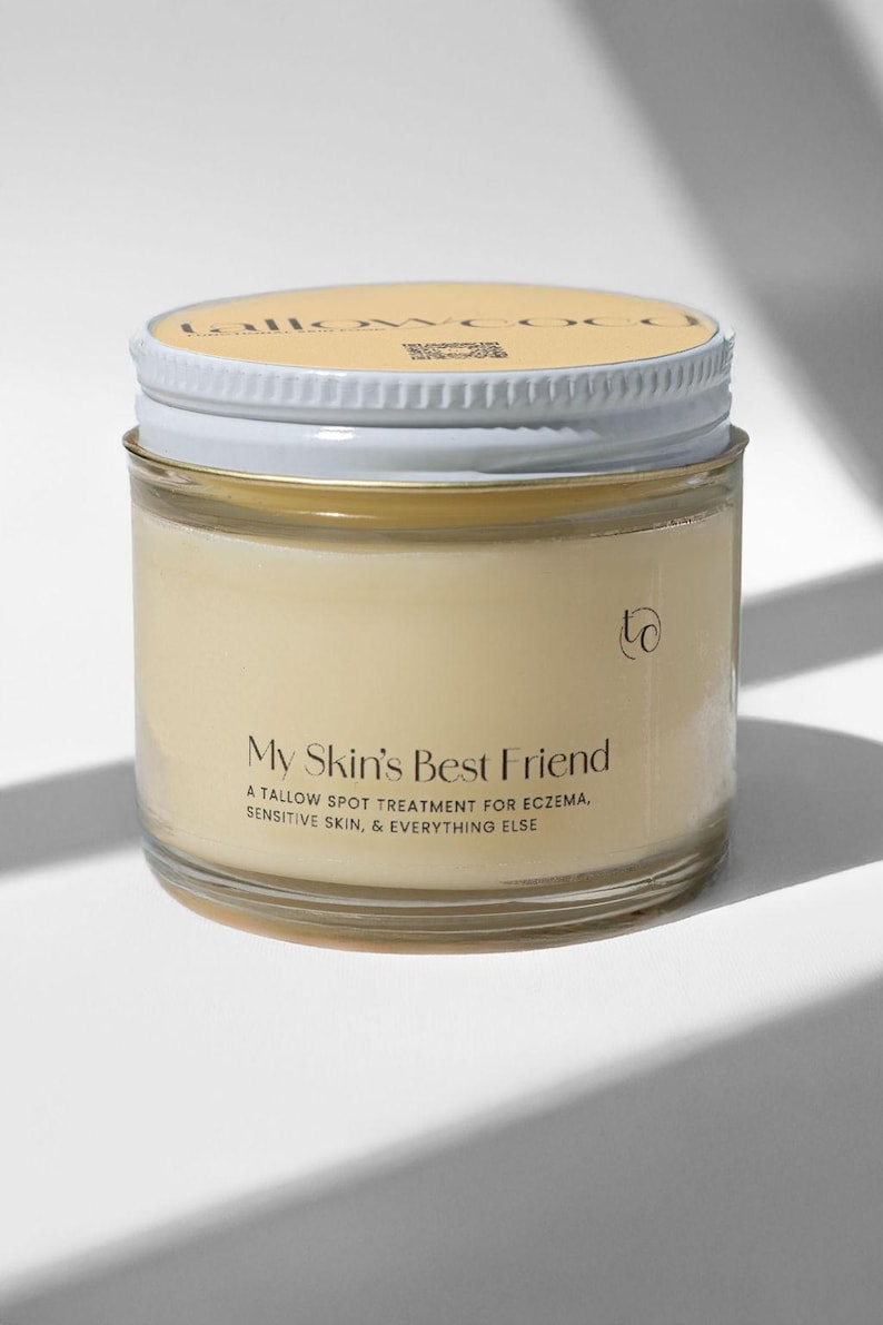 May include: A glass jar with a white lid containing a yellow cream. The label reads "My Skin's Best Friend A Tallow Spot Treatment for Eczema, Sensitive Skin, & Everything Else".